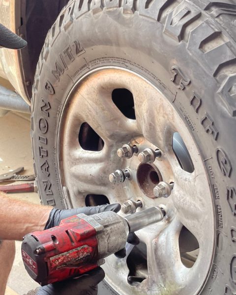 Removing a pickup truck wheel with an impact wrench for a brake job